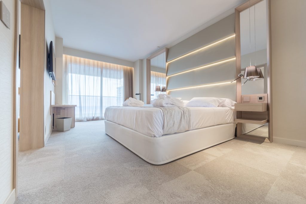 Habitación de hotel equipada con elevador de cama ergonómico DEMBECO